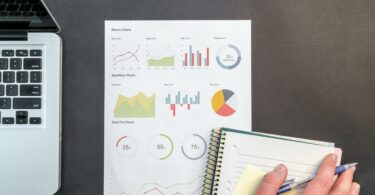 person holding blue ballpoint pen on white notebook