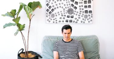 man sitting cozy while working on his laptop