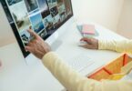 elderly man sitting by the desk and browsing on the computer
